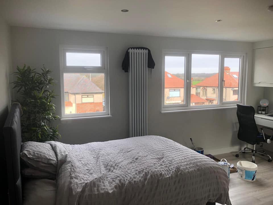 Finished loft bedroom with new radiator and window — Northwest loft conversion by RG