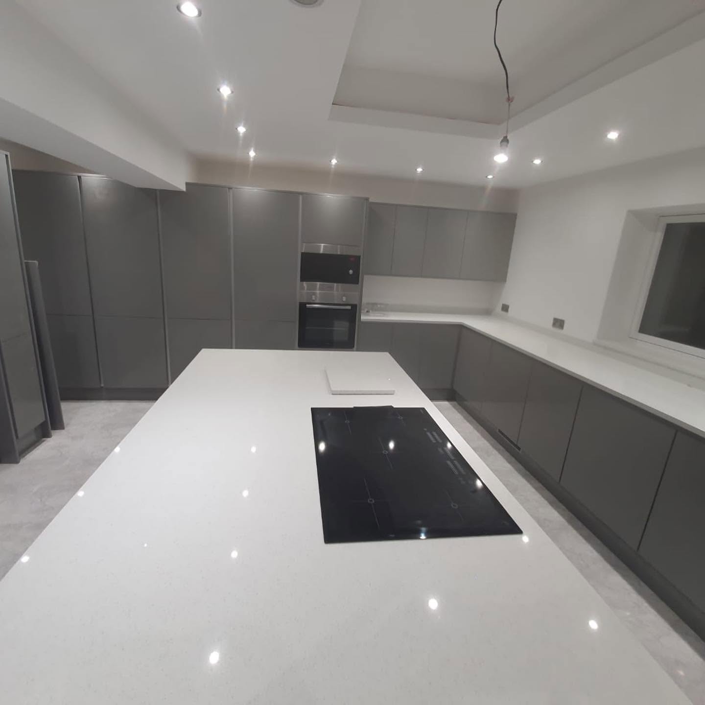Grey kitchen with white quartz island and induction hob — RG Northwest